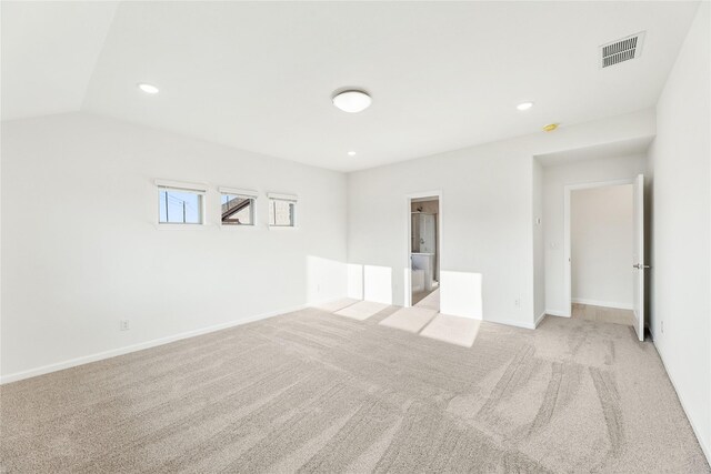 unfurnished room featuring lofted ceiling and light carpet