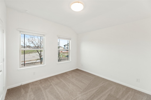 carpeted empty room featuring lofted ceiling