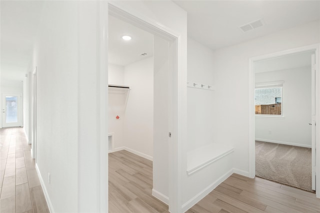 hallway with light hardwood / wood-style floors