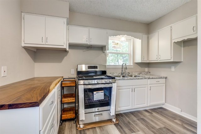 1541 Cloverdale Dr, Fort Worth, TX 76134 - kitchen featuring white cabinets, gas range, light wood-type flooring, and sink