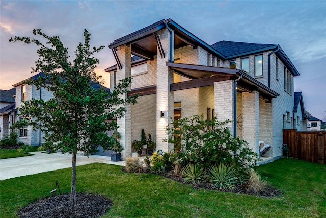 property exterior at dusk with a lawn