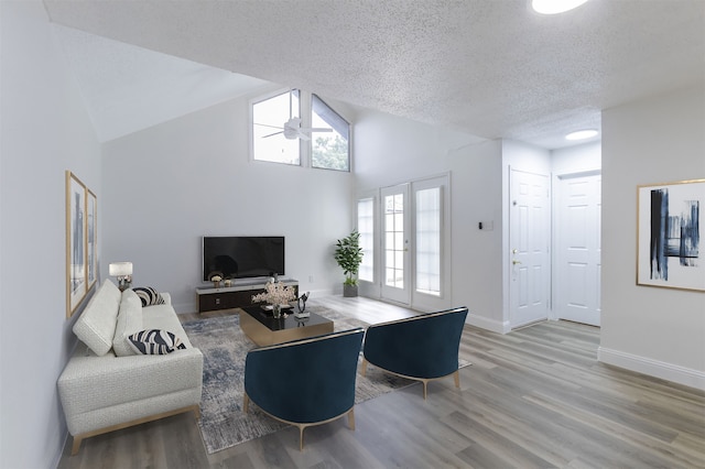 living room featuring hardwood / wood-style flooring, a textured ceiling, plenty of natural light, and french doors