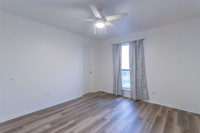 spare room with ceiling fan and wood-type flooring