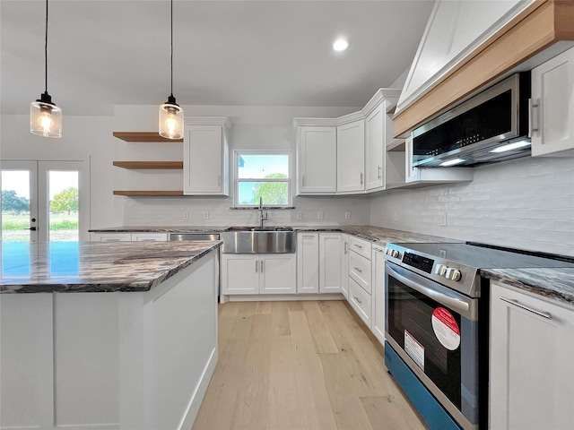 kitchen with decorative light fixtures, sink, white cabinets, decorative backsplash, and stainless steel appliances