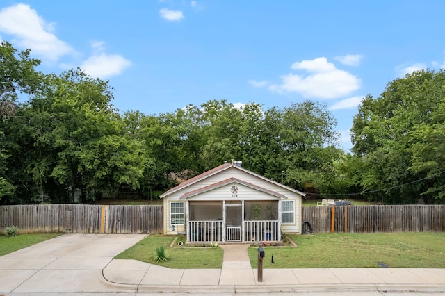 bungalow featuring a front lawn and a sunroom