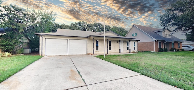 view of front of home featuring a garage, a porch, and a lawn