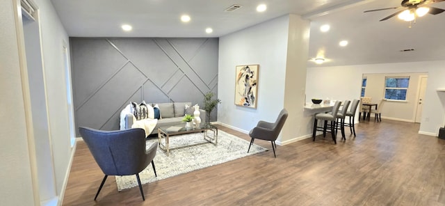 living room with ceiling fan and dark hardwood / wood-style flooring