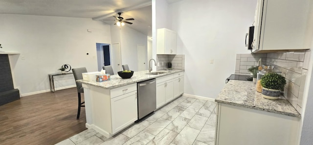 kitchen featuring stainless steel appliances, a kitchen breakfast bar, light stone countertops, white cabinets, and kitchen peninsula