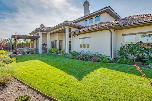 rear view of house featuring a pergola and a lawn