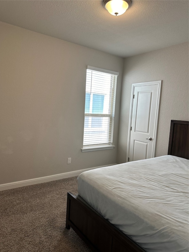 bedroom featuring a textured ceiling and carpet flooring