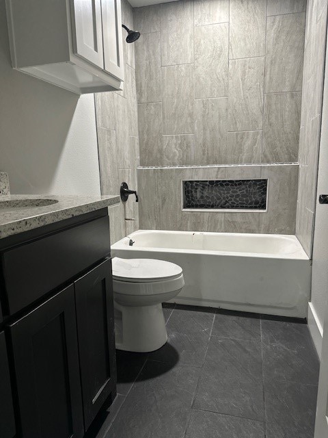 full bathroom with tile patterned flooring, vanity, toilet, and tiled shower / bath