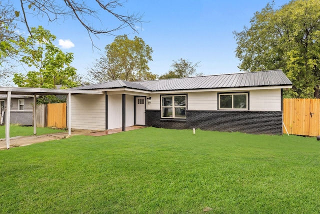 view of front of house with metal roof, fence, and a front lawn