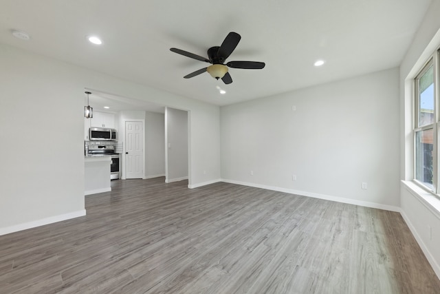 unfurnished living room featuring hardwood / wood-style floors and ceiling fan