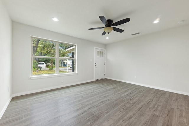 empty room with ceiling fan and hardwood / wood-style floors