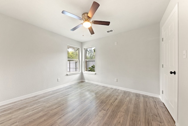 empty room with ceiling fan and light hardwood / wood-style floors