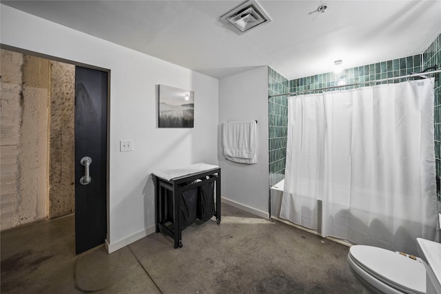 bathroom with toilet, concrete floors, and shower / bath combo with shower curtain