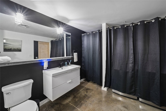 bathroom with vanity, concrete floors, and toilet