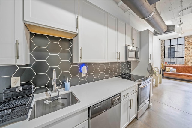 kitchen with backsplash, sink, white cabinets, and appliances with stainless steel finishes