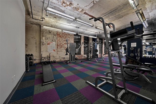 workout area featuring brick wall