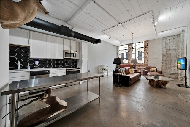 kitchen featuring stainless steel appliances, rail lighting, white cabinets, and tasteful backsplash