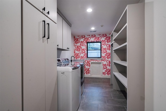 laundry room with washer and dryer and cabinets