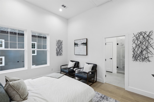 bedroom featuring connected bathroom and light wood-type flooring