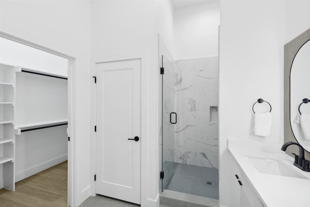 bathroom featuring vanity, wood-type flooring, and walk in shower