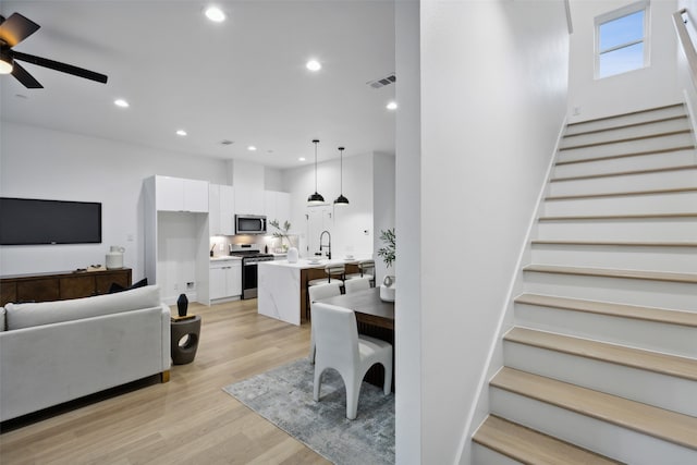 interior space with light wood-type flooring, ceiling fan, and sink