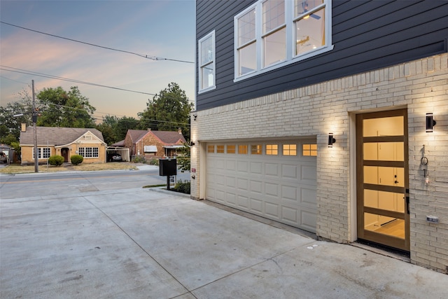 view of garage at dusk