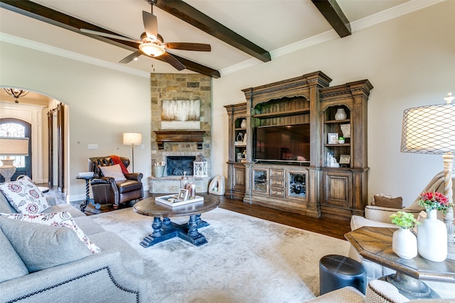 living room featuring a fireplace, hardwood / wood-style floors, beam ceiling, crown molding, and ceiling fan