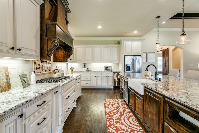 kitchen featuring white cabinets, crown molding, appliances with stainless steel finishes, dark hardwood / wood-style flooring, and sink