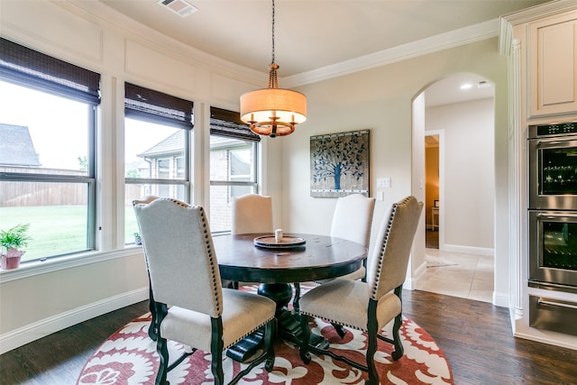 dining area featuring ornamental molding, dark hardwood / wood-style floors, and a chandelier