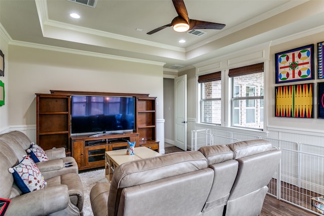 living room featuring a tray ceiling, ceiling fan, hardwood / wood-style flooring, and ornamental molding