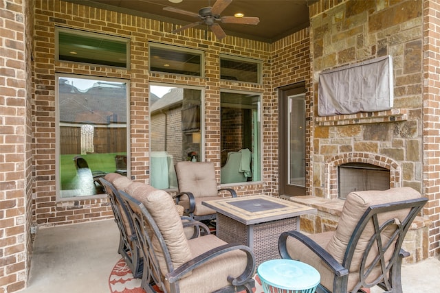 view of patio featuring an outdoor stone fireplace and ceiling fan