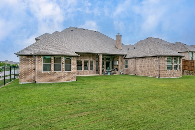 rear view of property featuring a yard and a patio area