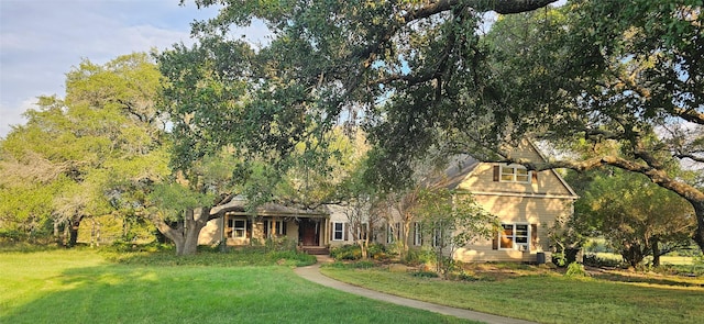 view of property hidden behind natural elements with a front yard