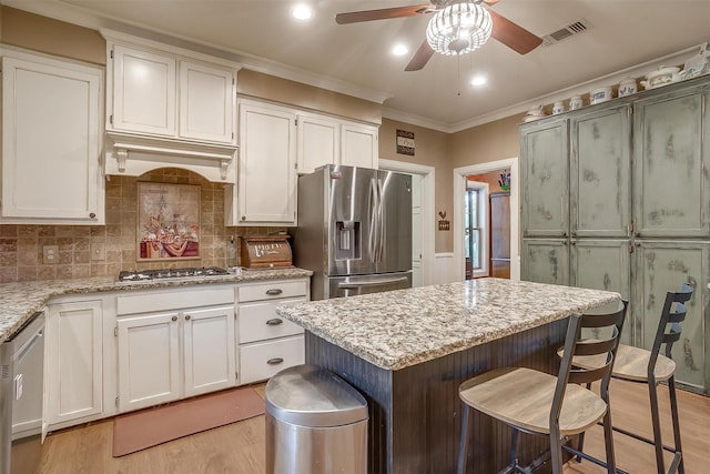 1645 County Road 1105, Rio Vista, TX 76093 - kitchen with ceiling fan, light wood-style flooring, ornamental molding, visible vents, and stainless steel appliances