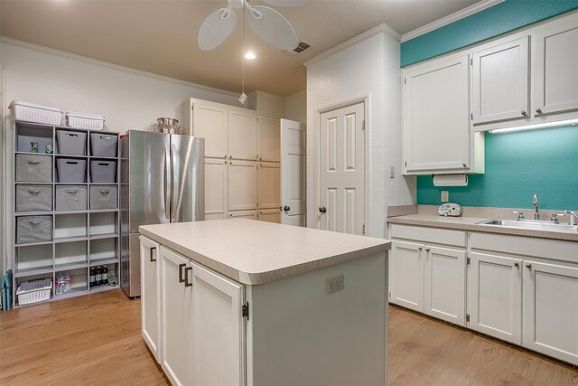 kitchen featuring white cabinets, a center island, and sink