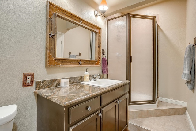 bathroom featuring toilet, vanity, and walk in shower