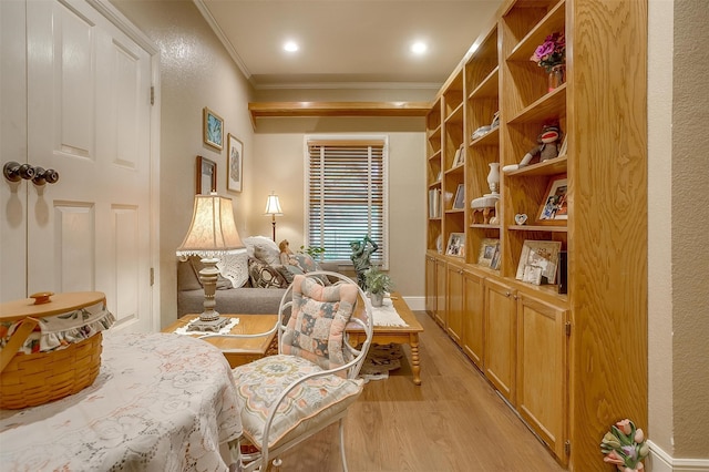 living area with light hardwood / wood-style floors and ornamental molding