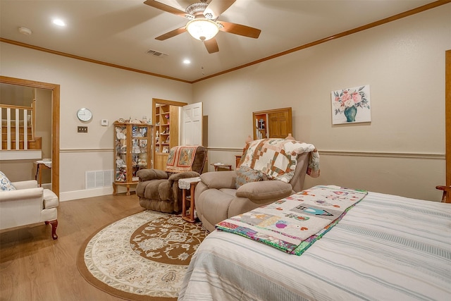 bedroom featuring ceiling fan, wood-type flooring, and crown molding