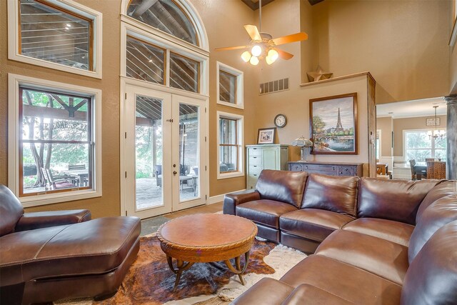 living room featuring ceiling fan, a healthy amount of sunlight, a high ceiling, and french doors