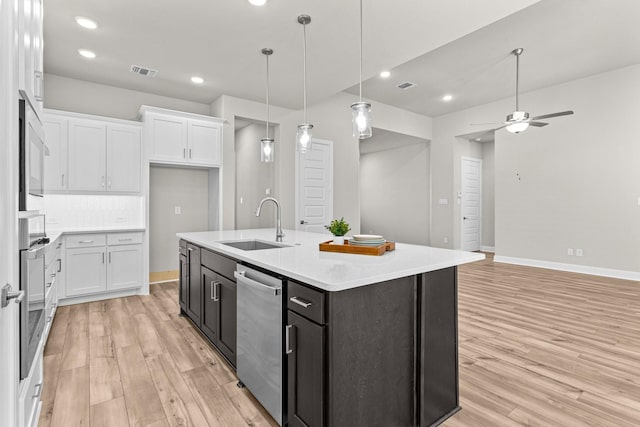 kitchen with decorative light fixtures, dishwasher, white cabinetry, decorative backsplash, and a kitchen island with sink