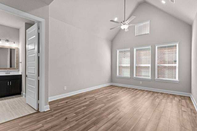 interior space with sink, vaulted ceiling, ceiling fan, and light wood-type flooring