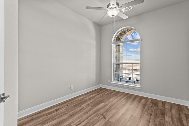 unfurnished room with ceiling fan, light wood-type flooring, and a wealth of natural light