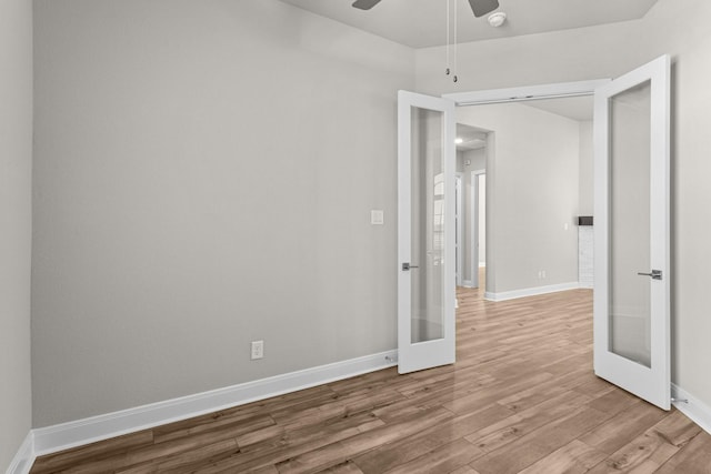 spare room featuring light hardwood / wood-style flooring, ceiling fan, and french doors