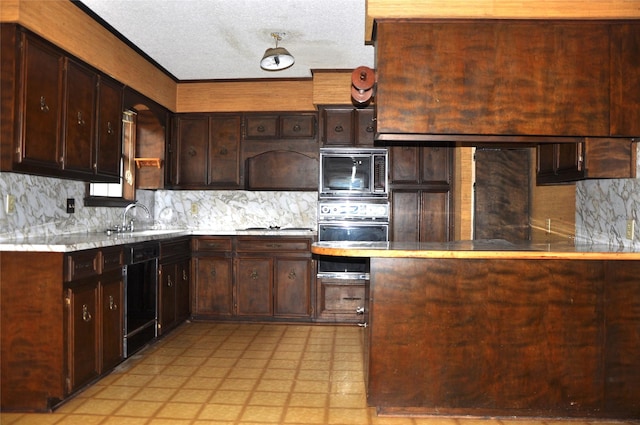 kitchen featuring light floors, a sink, light countertops, backsplash, and black appliances