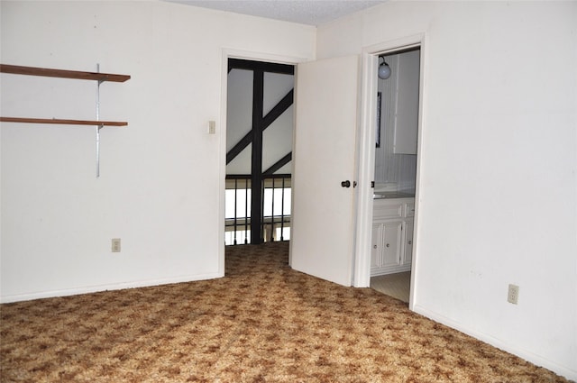 empty room with carpet floors and a textured ceiling