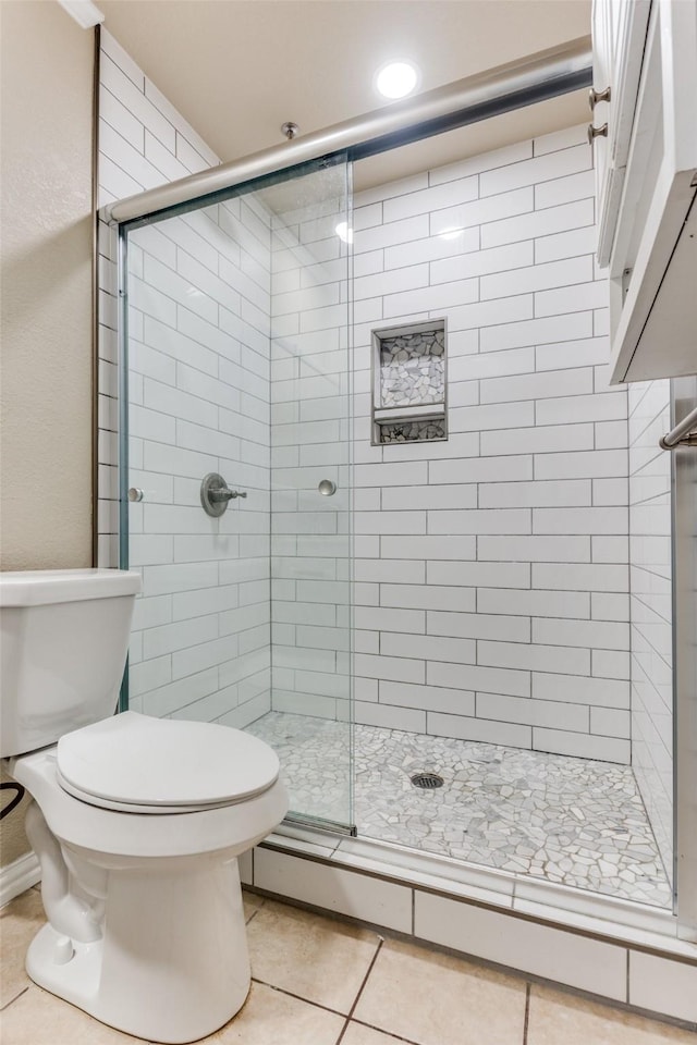 bathroom with tile patterned floors, an enclosed shower, and toilet