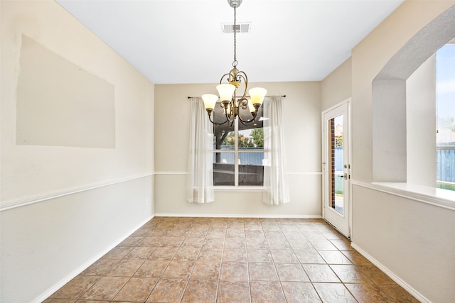 unfurnished dining area with light tile patterned floors, plenty of natural light, and a chandelier